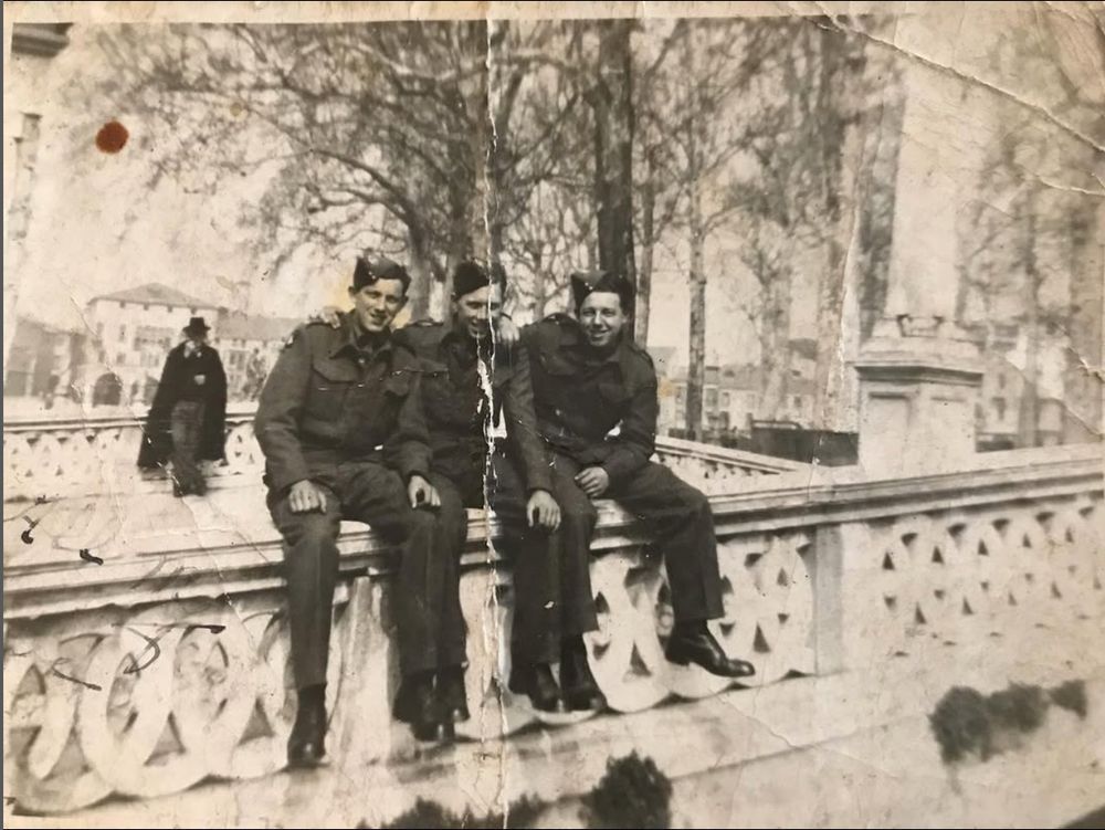 A mysterious cowled timelord enjoys a packet of Space Raiders (pickled onion, I am guessing) while sitting on a wall behind my granddad Tom and his army mates in Italy during WWII.