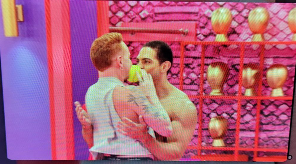 Same context as previous images. In this image, the tennis ball is between Pheonix and the pitcrew member's faces/lips (they win the game!)