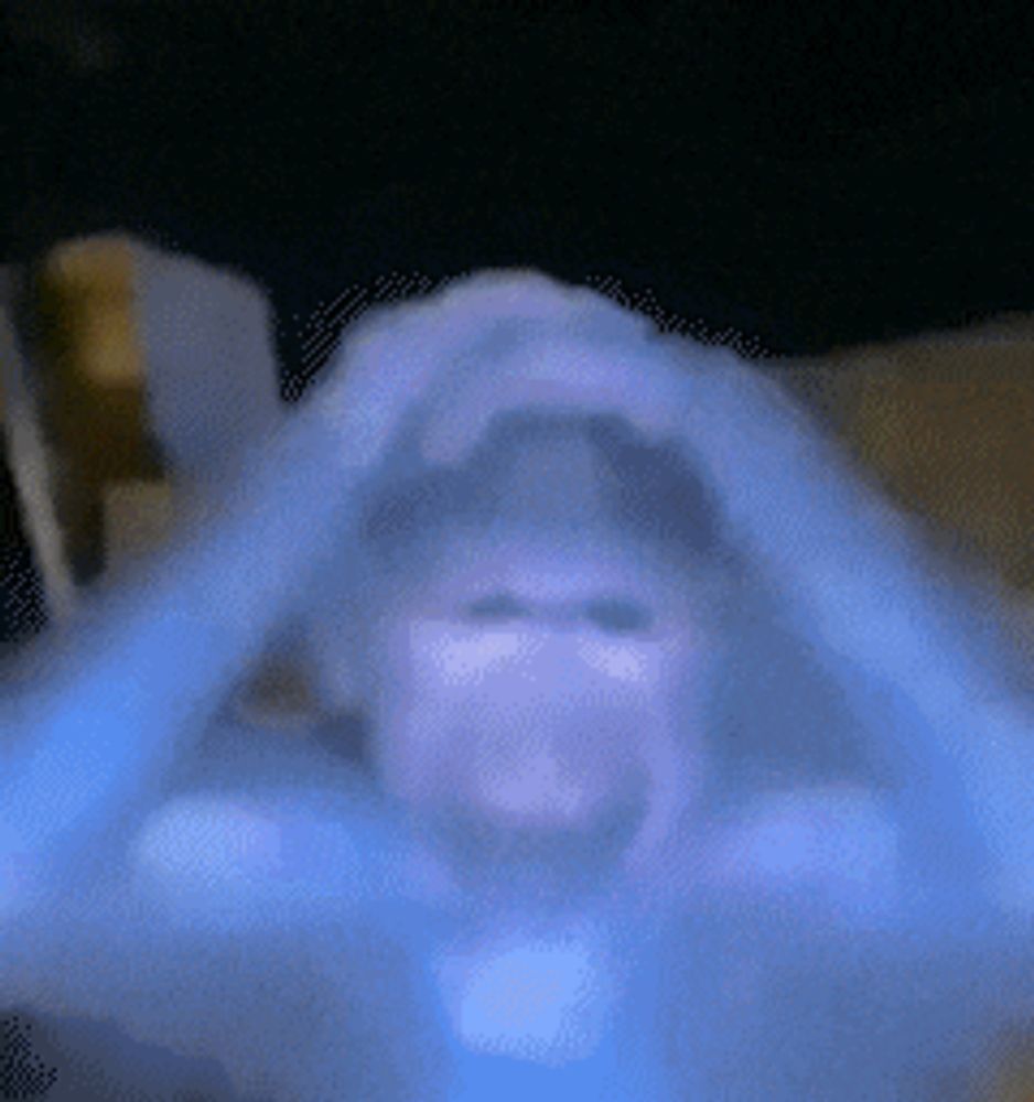 a blurry picture of a person 's face with a blue light behind them