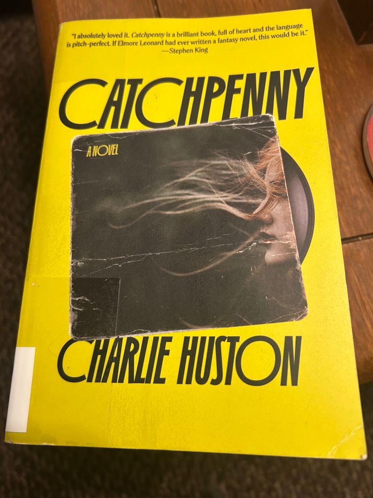 Picture of the book “Catchpenny” by Charlie Huston. Yellow with a picture of a record album depicting a blonde girl in profile, wind whipping her hair