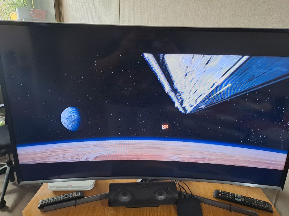 Photo of a TV showing the opening scene of Star Wars (Episode IV: A New Hope), where an Imperial Star Destroyer is pursuing a smaller ship on top of a planet.