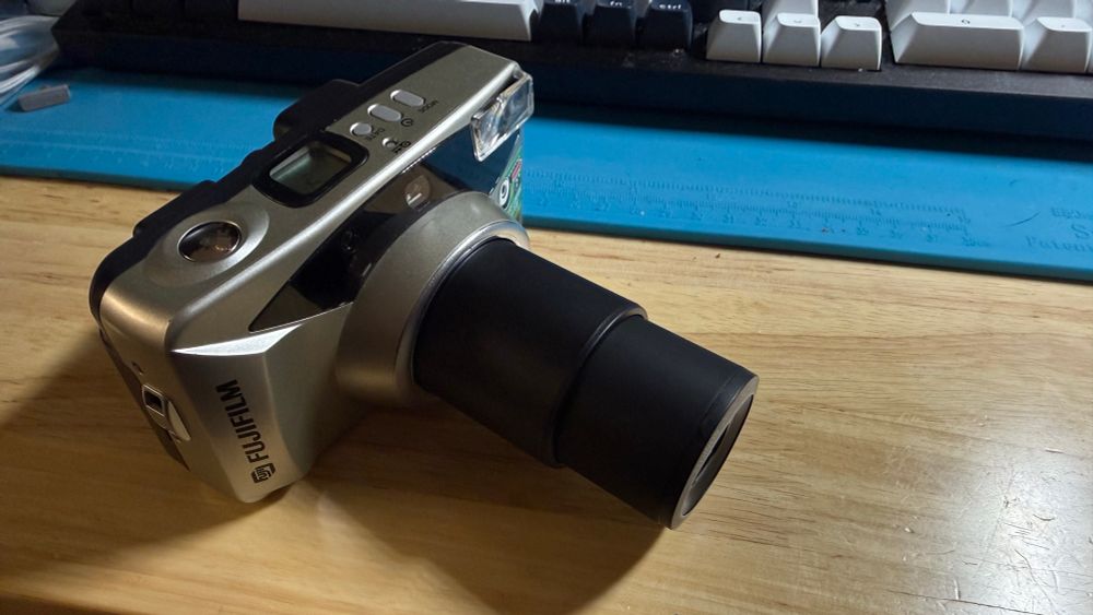 A Fujifilm Zoom Date 120 compact film camera with its lens at full extension. 