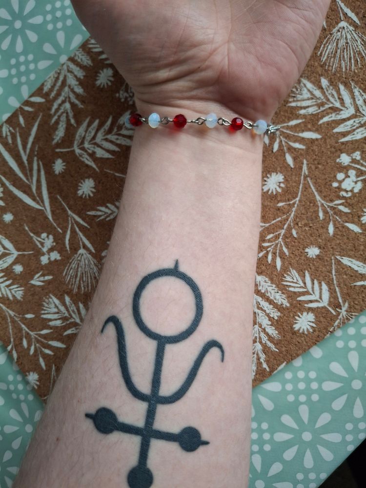 My creature arm wearing a bracelet of white and red shinies.
