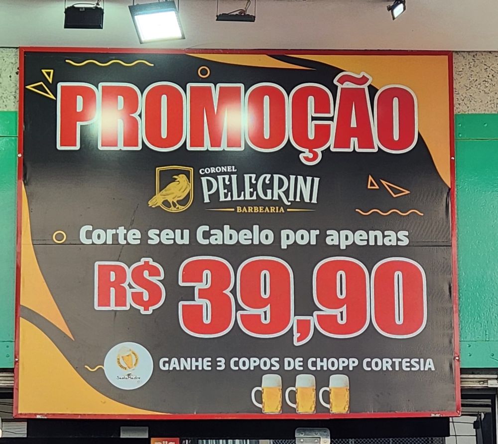 foto da placa de uma barbearia, em que se lê: "promoção. coronel pelegrini barbearia. corte seu cabelo por apenas R$ 39,90. ganhe 3 copos de chopp cortesia"