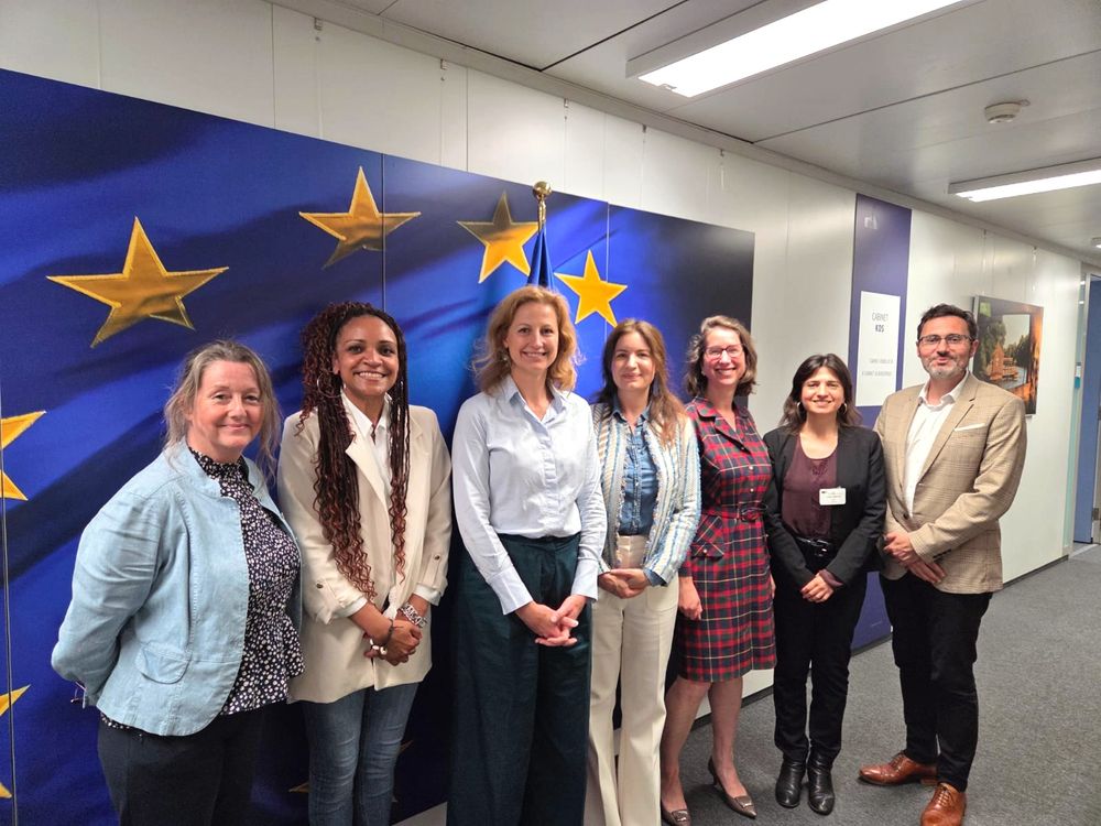 A group photo of six civil society representatives and one Cabinet member of Commissioner Kos in front of an EU flag. They all pose and smile for the camera following a meeting between them.