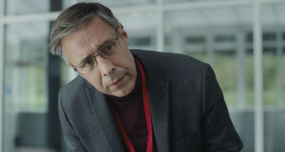 Image shows "The Zookeeper", a character from the movie Wolf (2021) played by Paddy Considine. He is in charge of a facility that tries to rehabilitate people who believe they are animals. 