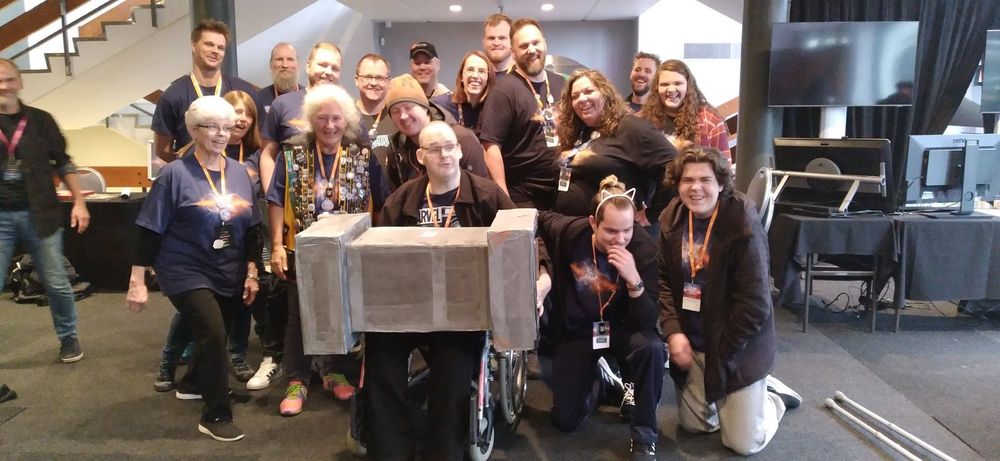 Group photo of the player volunteers at EVE Online Fanfest 2023 in Iceland, with the winner of our mystery loot box raffle sitting in front of us all.  Good times!