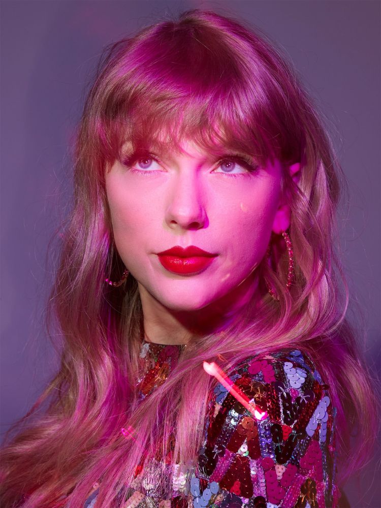 Taylor Swift is pictured face-on with her eyes looking upwards. She is wearing a sequined dress as part of a photoshoot for her appearance on SNL in 2021.