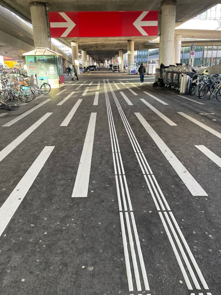 Ausgang am Bahnhof Hardbrücke in Zürich -Weiße Linien am Boden leiten hinaus.