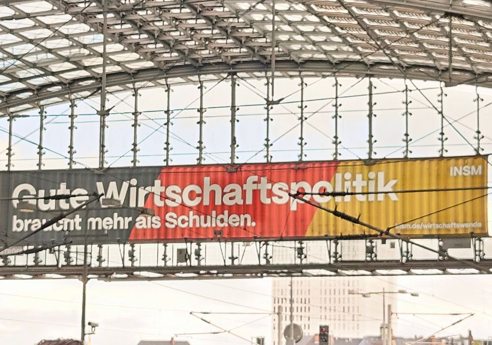 Banner am Berliner Hauptbahnhof des INSM. Gute Wirtschaftspolitik braucht mehr als Schulden.
