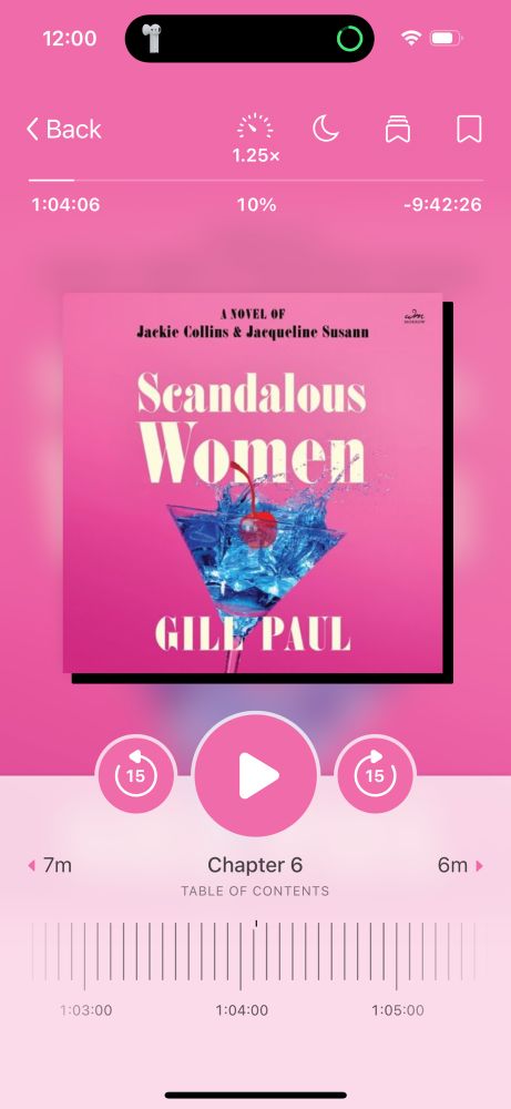 A screenshot of the audiobook flatscreen for the book Scandalous Women: A Novel of Jackie Collins and Jacqueline Susann by Gill Paul. It is a bright pink book with white text and a martini glass full of blue liquid and a red cherry. 