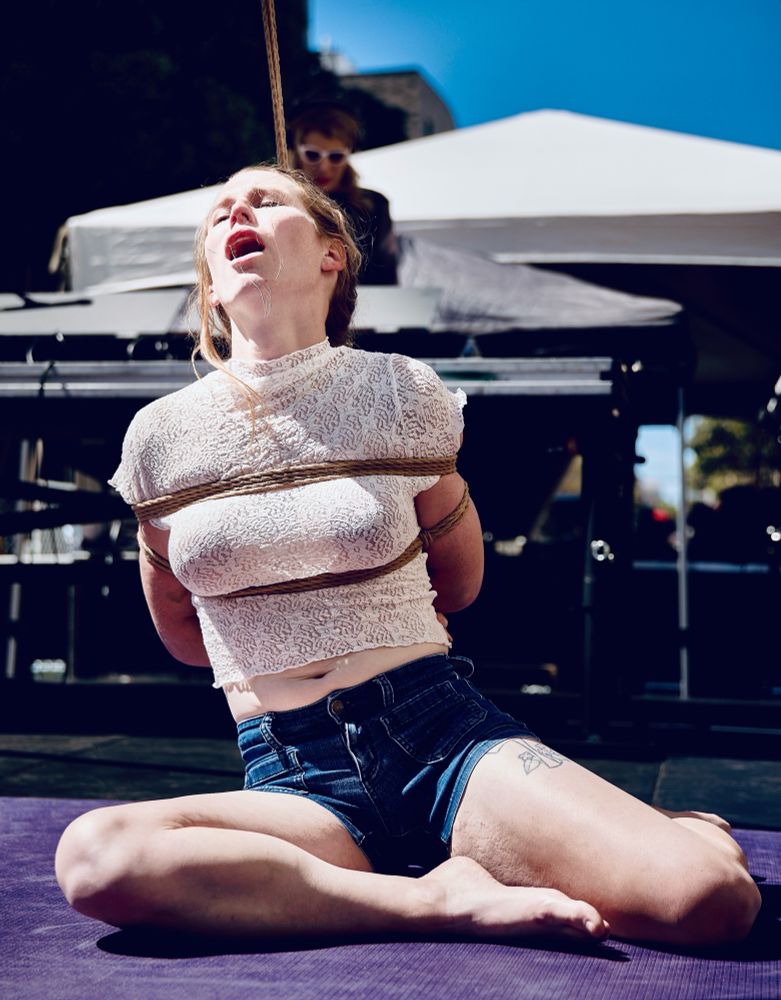 Slab_me_harder on the floor of the stage wearing a lace top and blue jean shorts in a TK