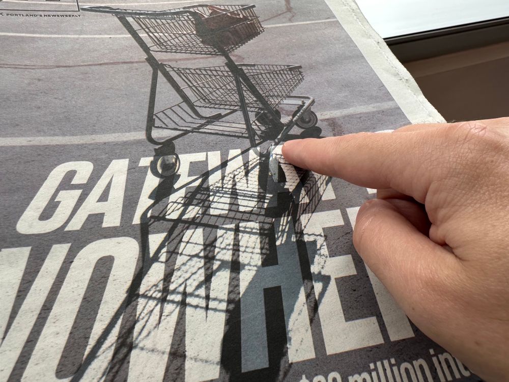 My finger is pointing at the bent corner of the shopping cart in the photo on the cover of the August 27 WW
