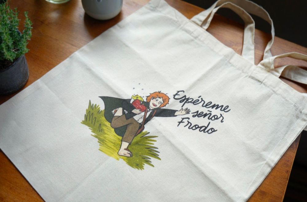 Tote bag con una ilustración de Samsagaz llevando un ramo y un paquete de bombones, mientras corre y grita "espéreme señor Frodo"