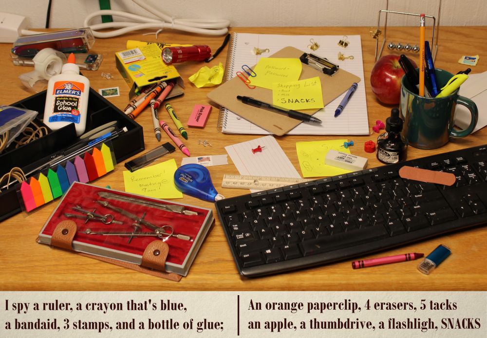 A picture of scattered office supplies, captioned with the riddle: I spy a ruler, a crayon that's blue, a bandaid, 3 stamps, and a bottle of glue; An orange paperclip, 4 erasers, 5 tacks, an apple, a thumbdrive, a flashlight, SNACKS.