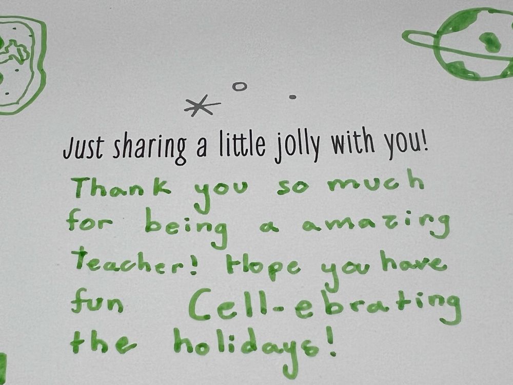 Card reads, “Just sharing a little jolly with you!” Underneath, in green marker, a student has written, “Thank you so much for being a amazing teacher! Hope you have fun Cell-berating the holidays!” 