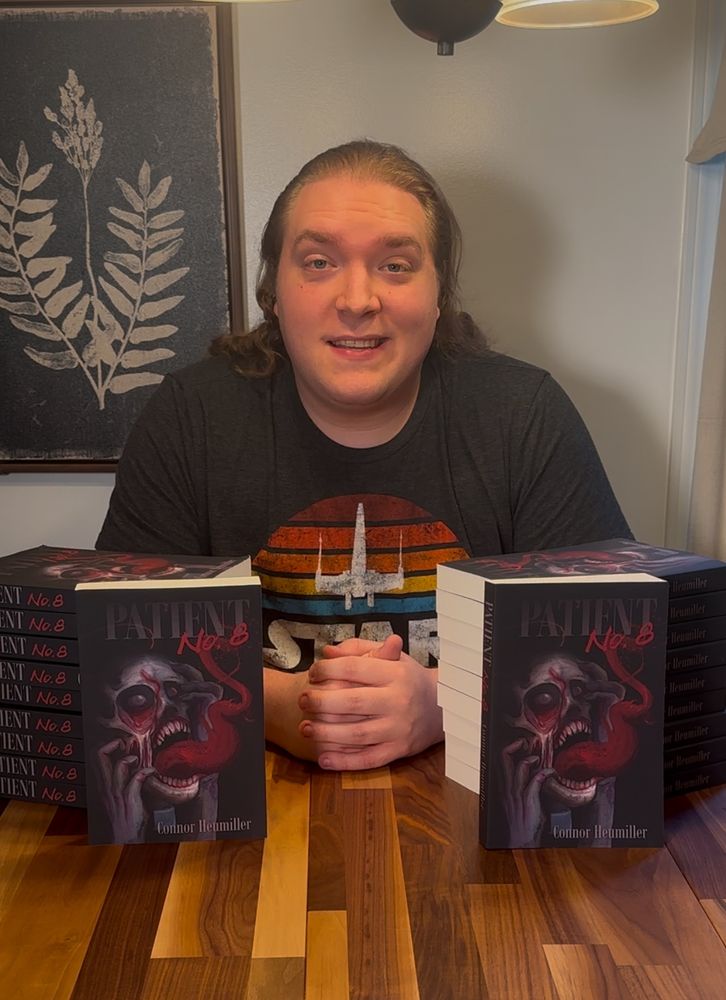 Author Connor Heumiller with copies of “Patient No. 8”