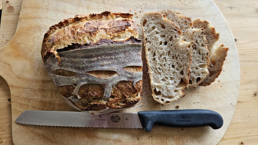 Sourdough bread cut open with bread knife on cutting board