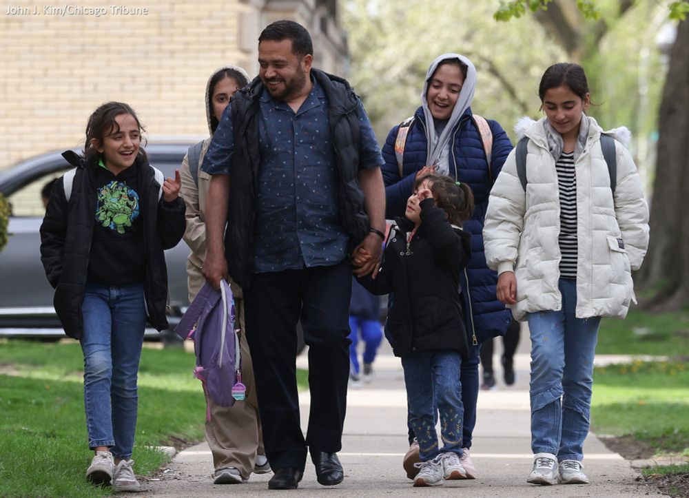 Hamid Azizi walks home with five of his seven children, including Zhra, 10, from left, Surya, 14, Sarah, 7, Roya, 13, and Razma, 12, after picking them up from school in the West Ridge neighborhood Friday, May 2, 2025, in Chicago. Azizi helped clear land mines in his native Afghanistan and assisted U.S. military special forces from 2017 until 2021, when the Taliban regained control of the nation. The family fled to Kabul, then Pakistan and Qatar, finally arriving in the U.S. in April. (John J. Kim/Chicago Tribune) 