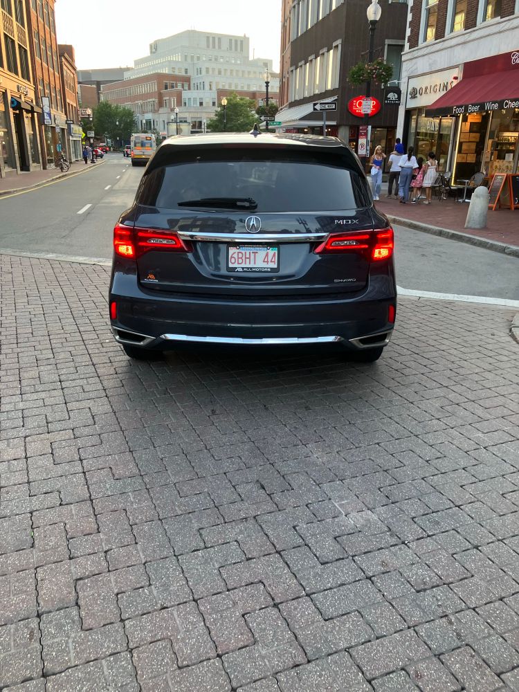 This car stopped halfway in a cycling lane in the middle of the intersection in Harvard Square. Flashers blinking. 
