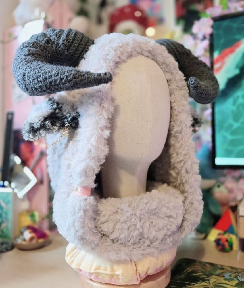 A white furry hood with grey horns on a mannequin head