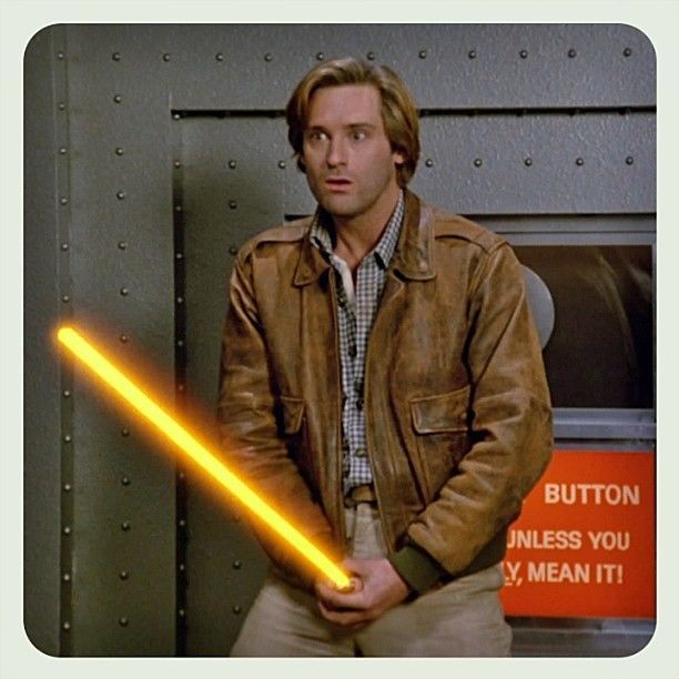 Lone Star from the movie Spaceballs. He is wearing brown pants, a plaid shirt, and a brown leather jacket just like Indiana Jones wears. In this scene he is holding his Schwartz at his crotch and it is glowing bright yellow.