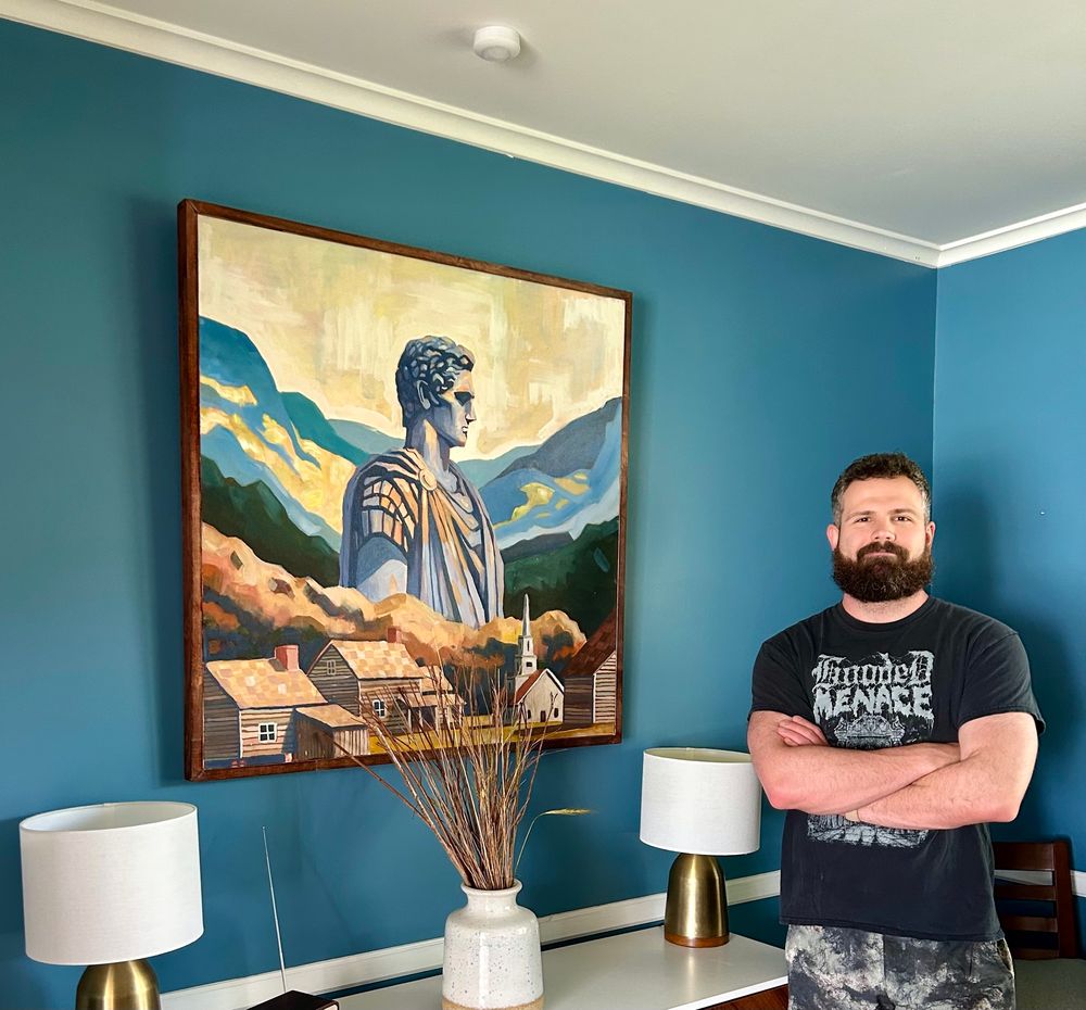 Artist standing next to a painting 