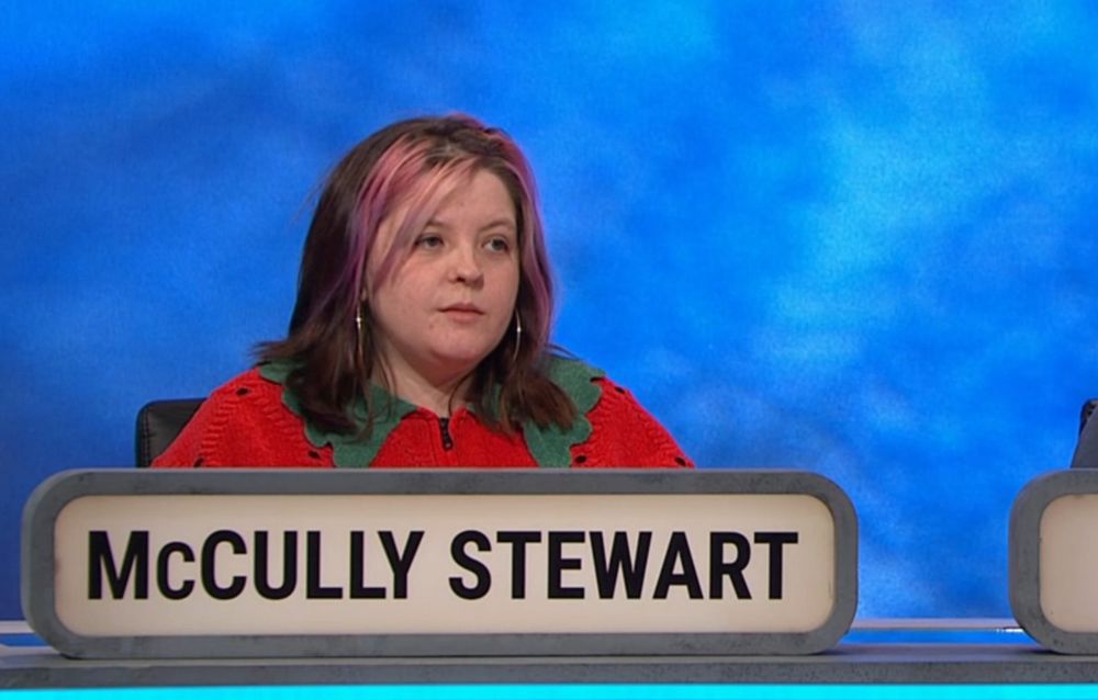 McCully Stewart wearing a jumper designed to look like a fresh strawberry.