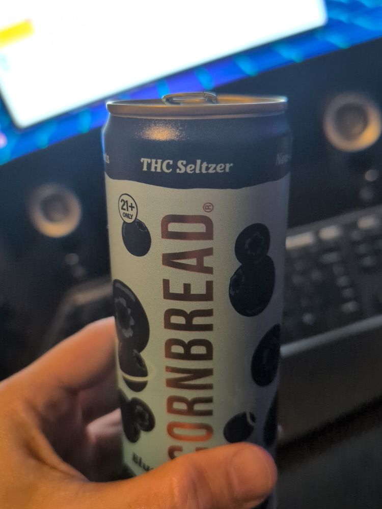 A hand holding up a THC seltzer.