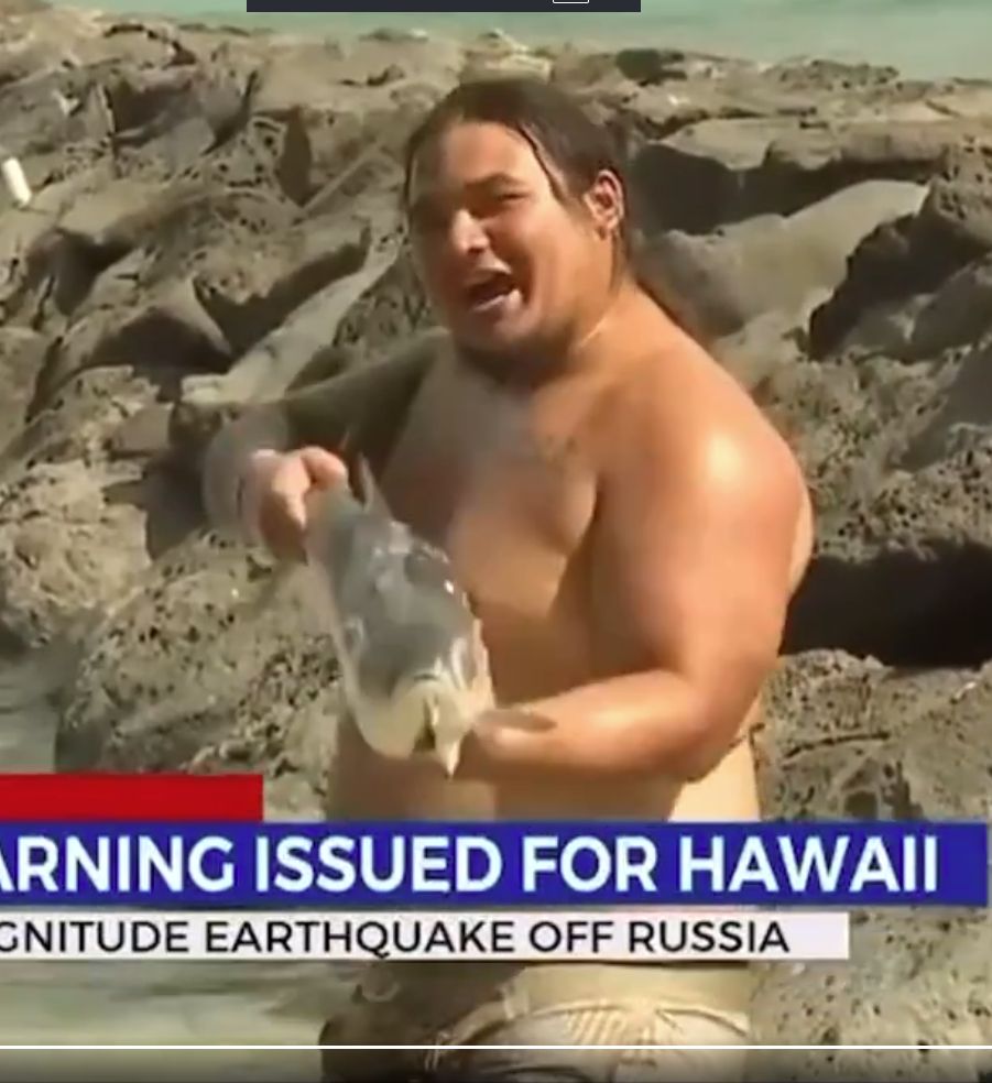 Some guy in Hawaii playing with a fish like it's a weapon. 