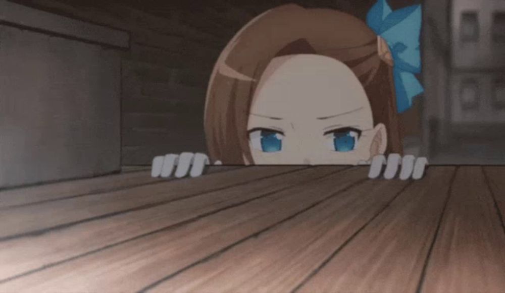 a girl with a blue bow on her head peeking over a wooden table