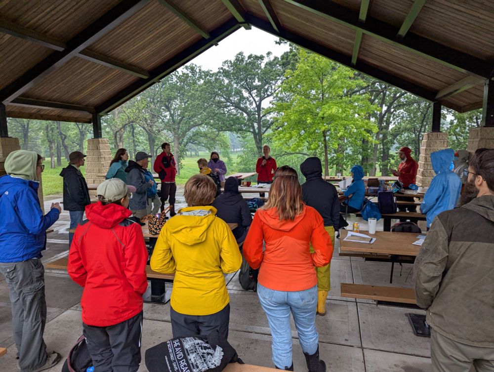 MSP LTER researchers standing in an outdoor pavilion at Battle Creek Regional Park watching a researcher give a field talk on lake/pond/stream research.
