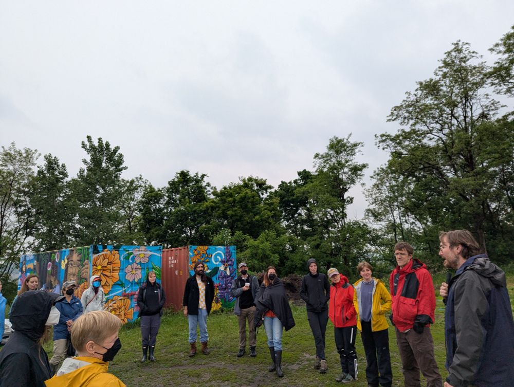 MSP LTER researchers standing outside in a circle at Rivoli Bluffs Farm & Restoration Site, listening to David Woods from Urban Roots talk about joint research at the site.