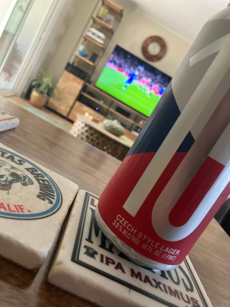 a can of 3.9% ABV czech lager in front of the Manchester United vs Rangers match. 