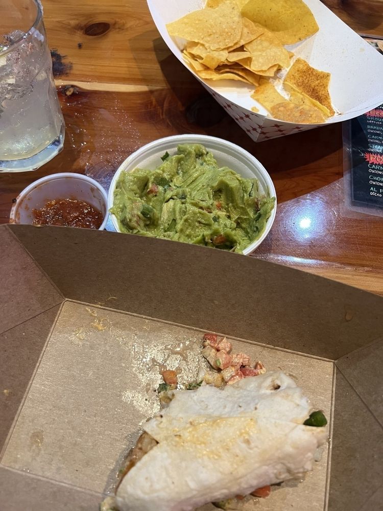 Half a grilled shrimp taco, a cup of guac, and a second margarita have ￼joined the now nearly chops and salsa containers. 