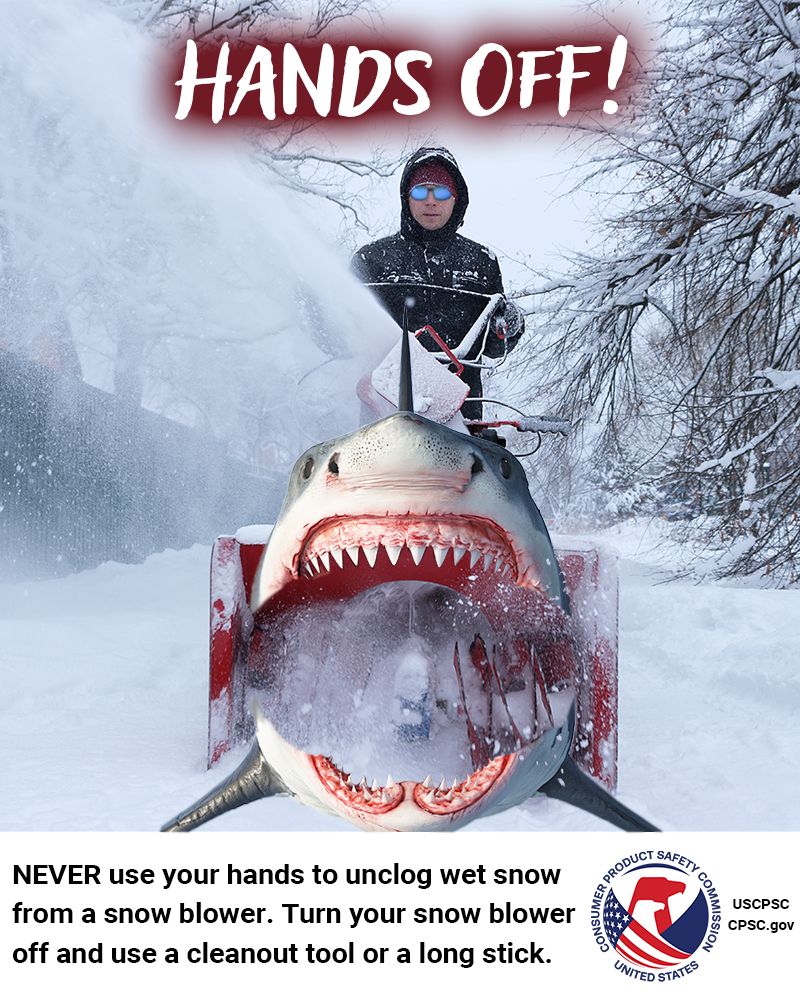 A person safely using a snow blower to move some snow. The snow blower has the face and body of a Great White shark. The text reads: Hands off! Never use your hands to unclog wet snow from a snow blower. Turn your snow blower off and use a cleanout tool or a long stick.