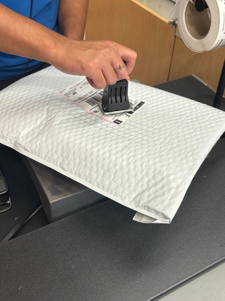 A package getting stamped by the postal office employee. 