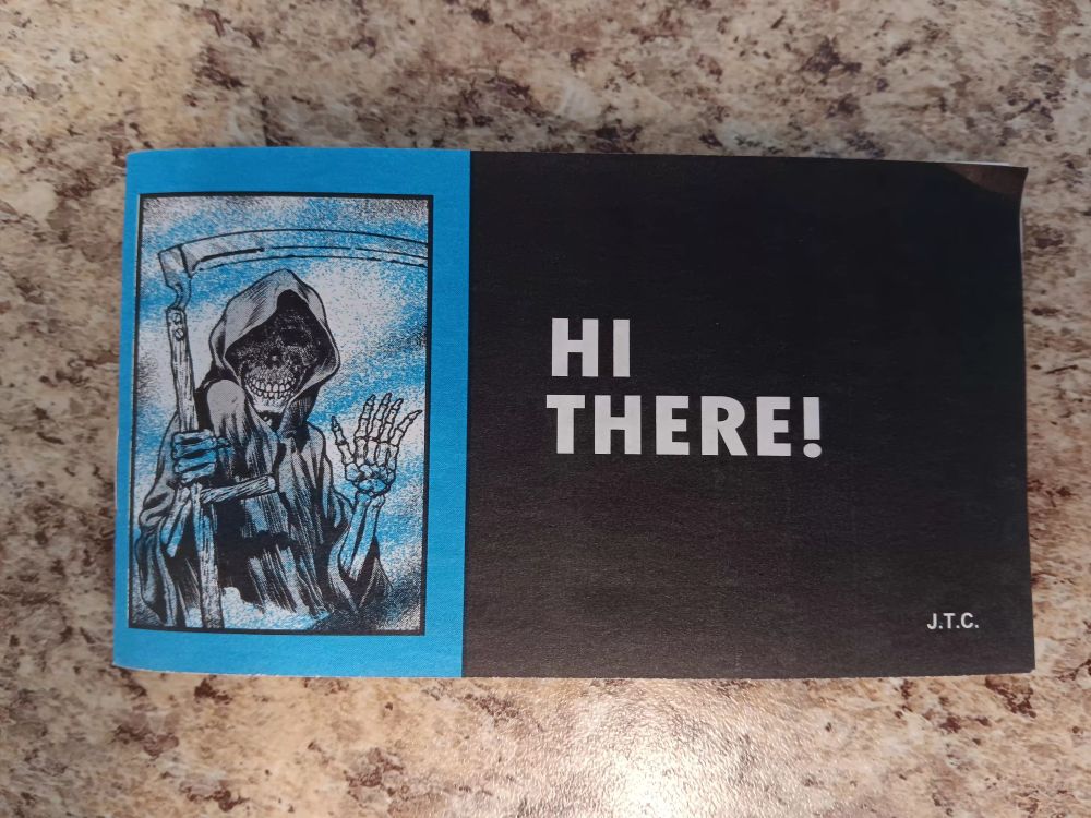 A Chick Tract (weird evangelical religious comic booklet). The front cover has a drawing of the grim reaper waving at the reader, title reads "HI THERE!"