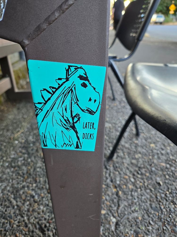 A sticker outside at OGR, a sketch of a dinosaur captioned "Later, dicks"
