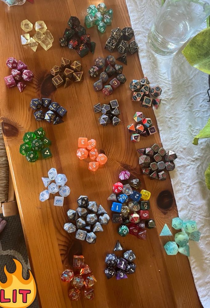 a photo of a table covered in many colorful sets of ttrpg dice