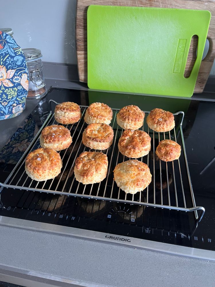 A photo of a batch of cheese scones cooling on a wire rack 
