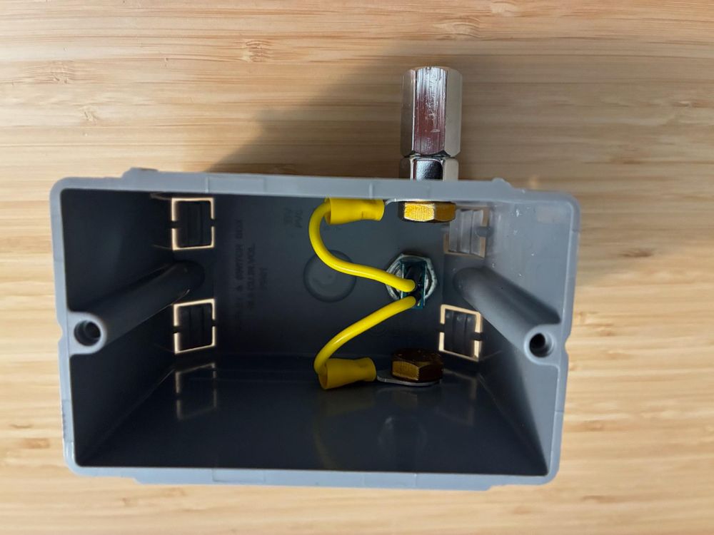 Photo of the interior wiring of the test box showing SPST switch in the middle and wires leading up and down to 3/8-24 bolts. This is intended to attach to a ground spike on the lower side and radials/coax-feed/whip on the top side.