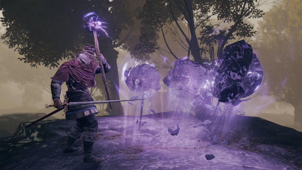 the wizard, again, is now casting a spell with her staff to pull boulders out of the ground using gravity magic (seen as a purple aura around the staff and rocks), as if to sling them at her enemies (none are present in the image, however).