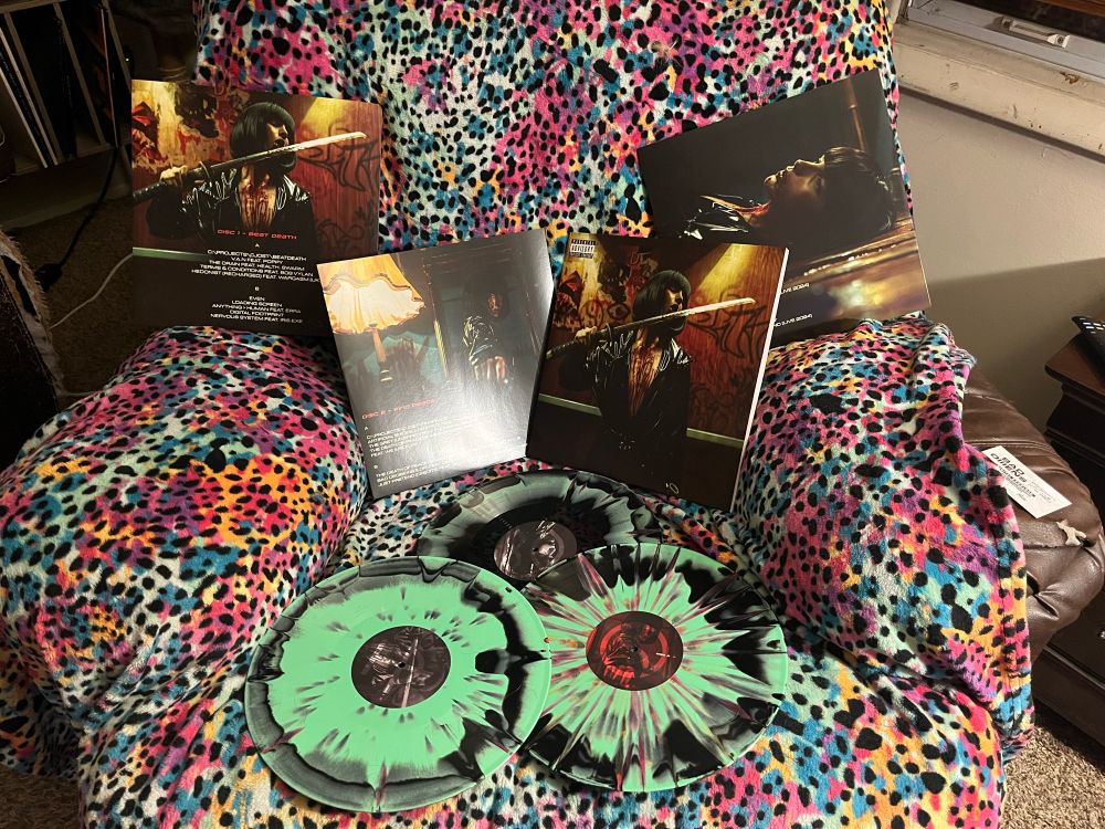 A display of Concrete Jungle 3 vinyl and slip cases. Green and black red splatter. 