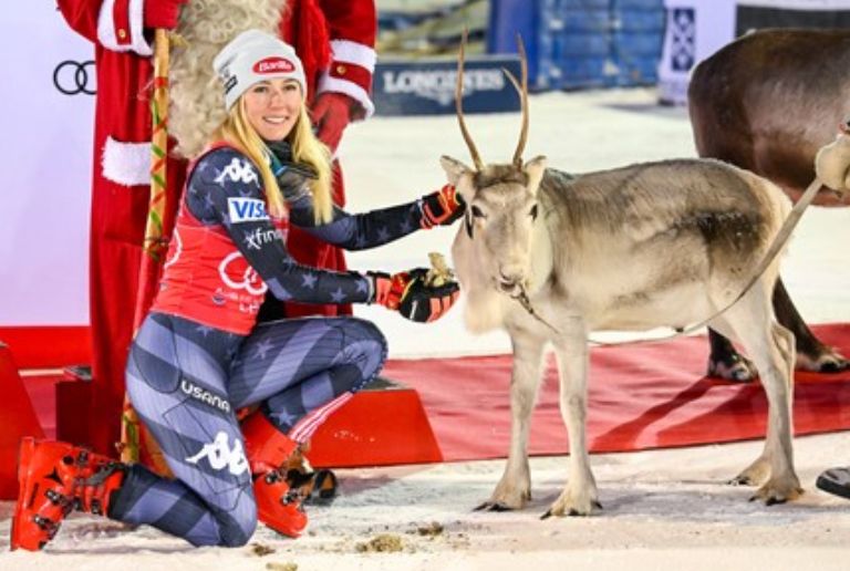 World Cup champion ski racer, Mikaela Shiffrin, posing with a small reindeer, a prize to the winner of the first race of the year in Finland