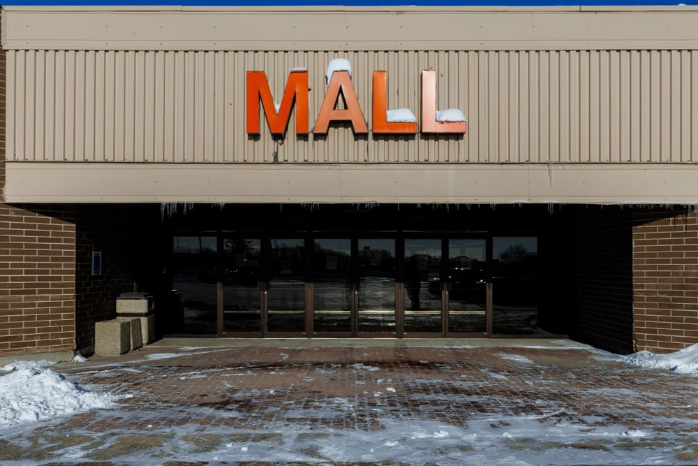 Set of doors that open into the Portage la Prairie Mall with just the very large word "MALL" hanging above. 