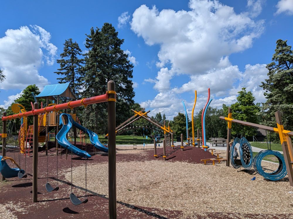 The Powderhorn Park play structures, a swing set, slides, monkey bars, play house. 