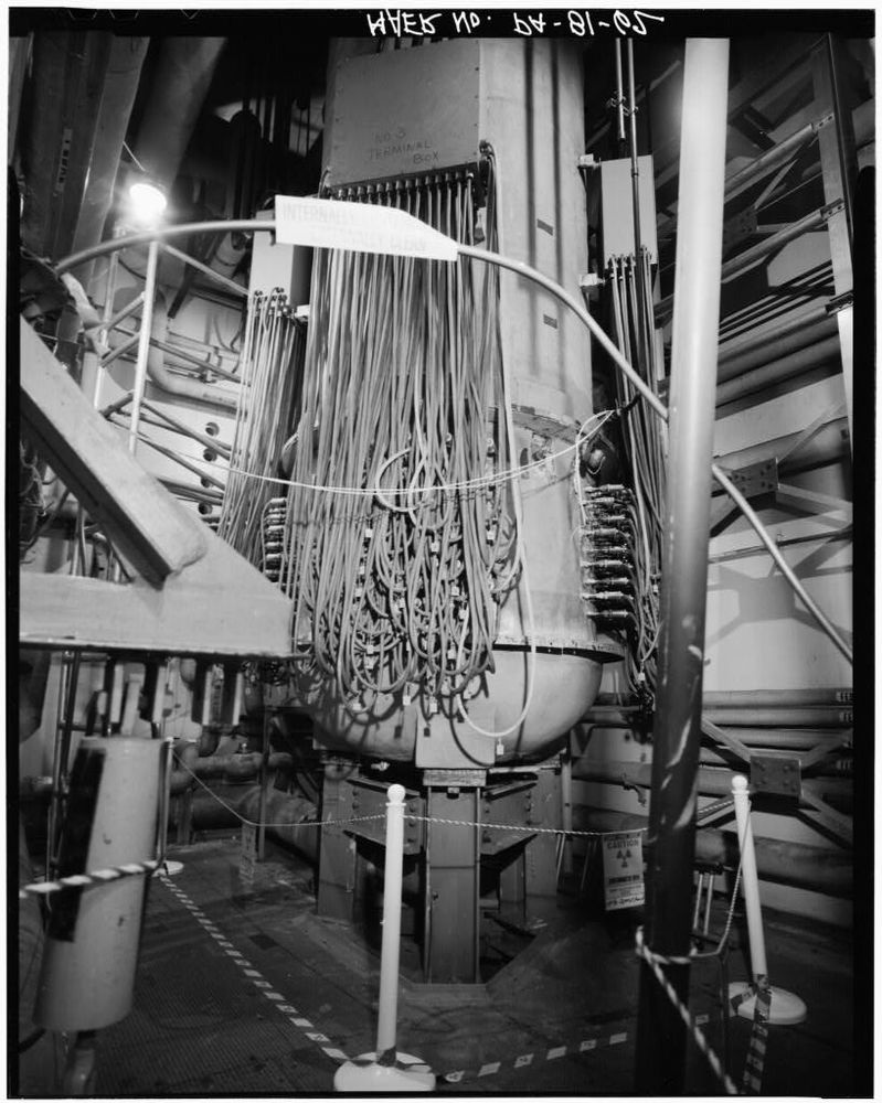 A vessel hanging above the floor with dozens of cables going into it. This is the shippingport pressurizer.