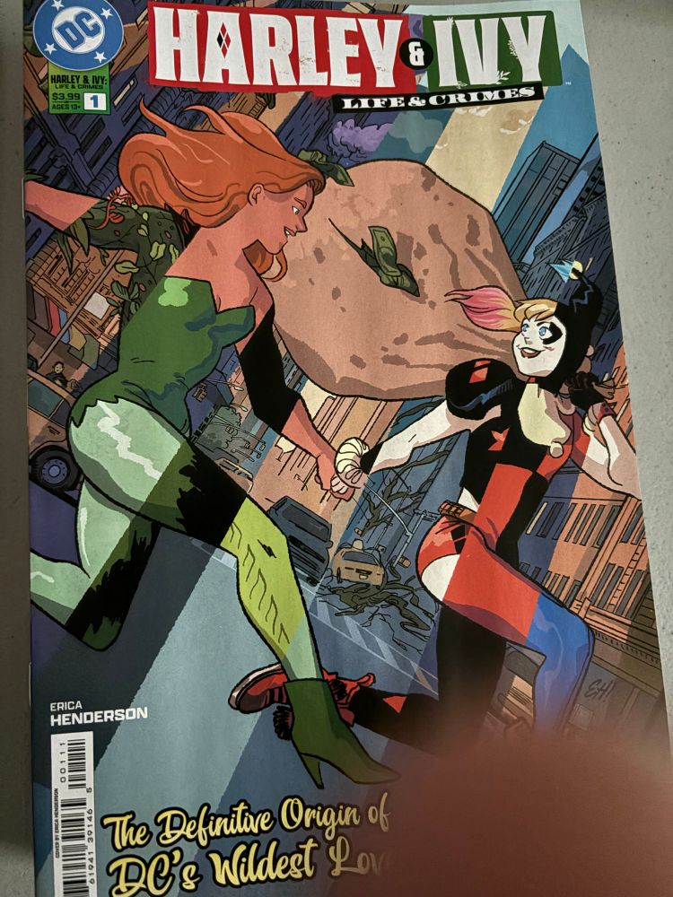 Cover of Harley & Ivy: Life & Crimes #1 by Erica Henderson. Featuring Poison Ivy and Harley Quinn holding hands as they run through the streets with loot. The stripes of the issue cover containing their various costumes. 