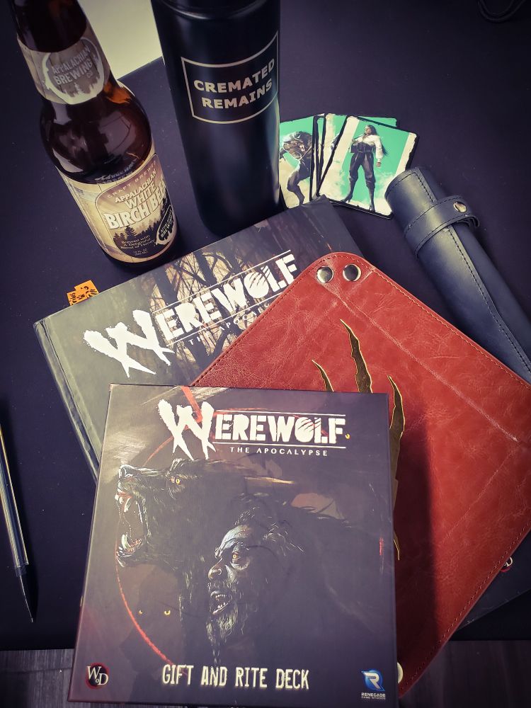 "Werewolf: The Apocalypse" 5th Edition core book, plus a dice tray, a dice holder, and a box of Werewolf "Gift and Rite" supplement cards.